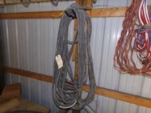 (2) Black, Heavy Duty Extension Cords Hanging On Back Wall (Warehouse Back