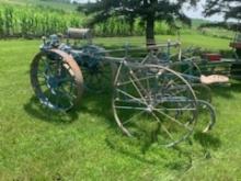 Blue Tractor on steel with mounted cultivator, engine is loose, has "St. Paul Minn." sticker on side