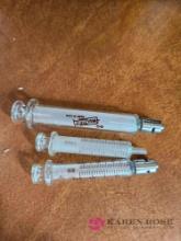 Three glass syringes
