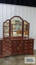 Cherry dresser with tri-fold mirror made by Knob Creek. 81 in. tall to the top of the mirror. 68 in.