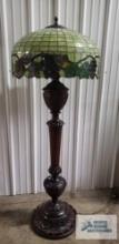 Antique wooden carved floor lamp with antique leaded glass shade with grape base. 67 in tall. Base