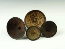 Set of four beautifully carved wood spin-tops from New Guinea. Largest is 4" diameter.