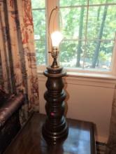 (UPOFC) MID CENTURY TURNED WALNUT TABLE LAMP WITH BRASS BASE & BRASS HARP. IT MEASURES 31-1/4"T.